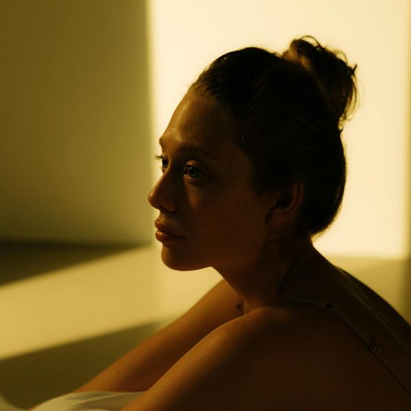 Person meditating peacefully with soft, warm light around them.